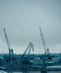 Fototapeta na wymiar Image of river, floating cranes, buildings on river bank.