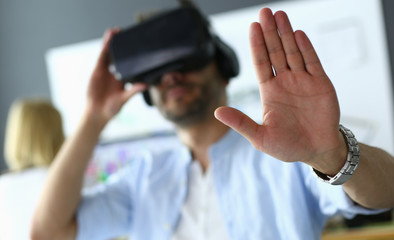 Young male software programmer testing a new app with 3d virtual reality glasses in office.