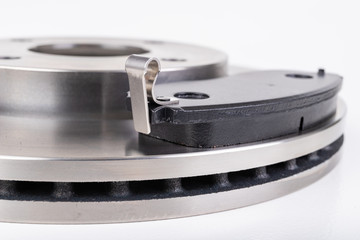 Steel brake discs and brake pads for a passenger car. New spare parts for car repairs.