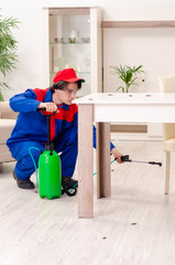 Young contractor doing pest control at home