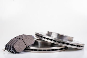 Steel brake discs and brake pads for a passenger car. New spare parts for car repairs. © Piotr