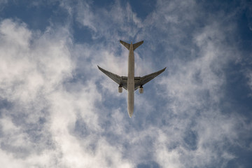 Fototapeta premium Airplane on blue sky with clouds. Travel around the world in the air