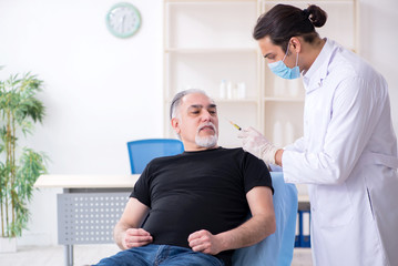 Fototapeta premium Old man visiting young doctor for plastic surgery