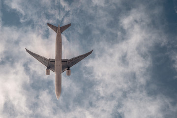 Airplane on blue sky with clouds. Travel around the world in the air