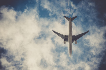 Airplane on blue sky with clouds. Travel around the world in the air