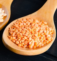 The spoons filled with uncooked lentil for soup