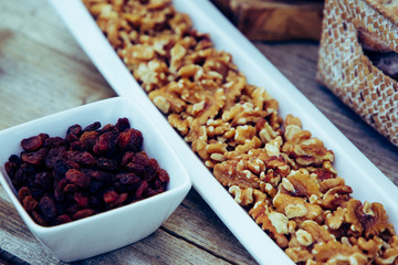 recipientes con nueces y pasas sobre madera