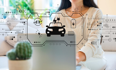 EV with woman using her laptop in her home office