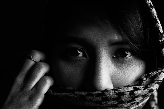 Close-up pictures of sad eyes and faces of Arab women There are freckles on the face and face covering fabric.