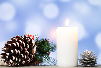 Christmas decoration and candle on blue background