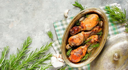 Baked chicken drumsticks with rosemary on a concrete background. top view. copy space. keto recipe, low carb