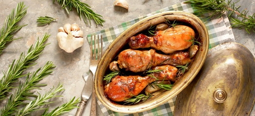 Baked chicken drumsticks with rosemary on a concrete background. top view. copy space. keto recipe, low carb