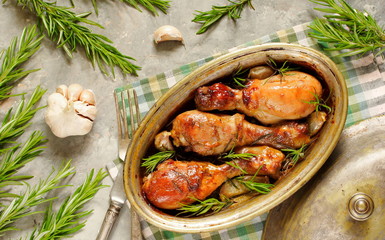 Baked chicken drumsticks with rosemary on a concrete background. top view. copy space. keto recipe, low carb
