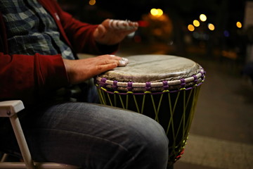 musician plays drums on the street at night