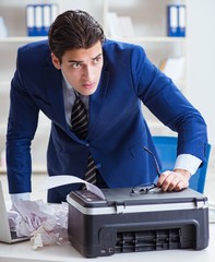 Businessman angry at copying machine jamming papers