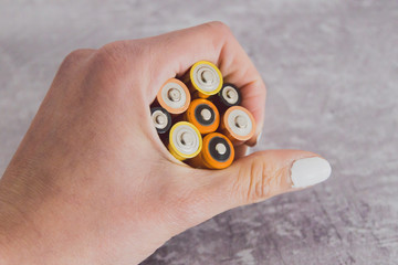 hand holding group of alkaline batteries