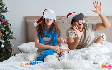 Obraz na płótnie Canvas Happy couple celebrating christmas holiday in bed