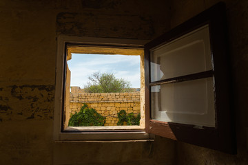 An Open Window Revealing the Brick Walls of a Citadel in Gozo, Victoria (Malta)