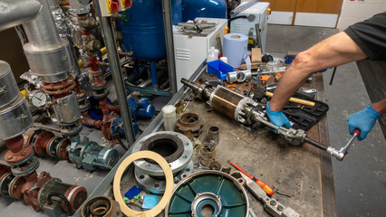 Mechanical engineer removing bearings from an armature