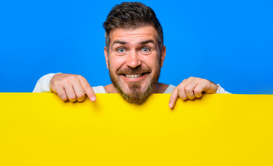 Bearded man shows empty placard ready for your text or product. Happy man presenting empty...