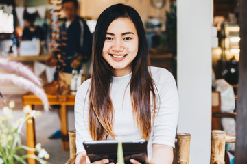 Beautiful asian women use tablet computer in coffee shop