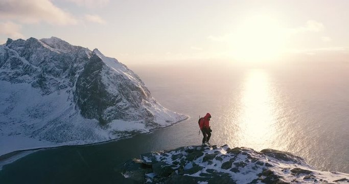 Scandinavia winter scenery with hiker at sunset, Lofoten, Norway