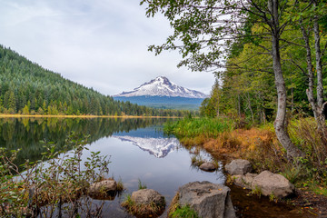 Obraz premium Mt. Hood reflecting in Trillium Lake with rocks and trees in an idyllic scene