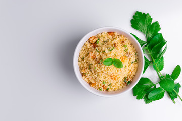 Delicious homemade vegetarian couscous with dates, raisins, parsley, tomato, lemon and olive oil in...