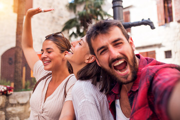 Obraz premium Smiling friends make looking at camera and make selfie