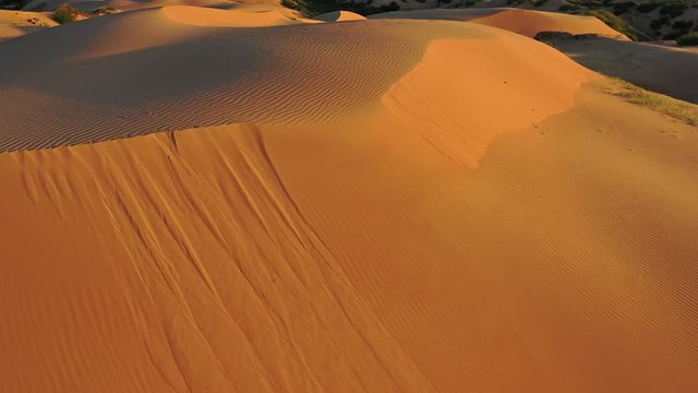 Aerial top view on sand dunes in desert at sunrise, 4k