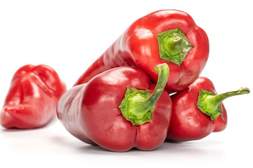Group of four whole sweet red bell pepper isolated on white background