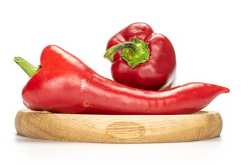Group of two whole sweet red bell pepper on bamboo plate isolated on white background
