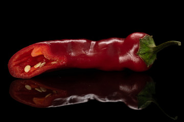 One half of fresh hot pepper isolated on black glass