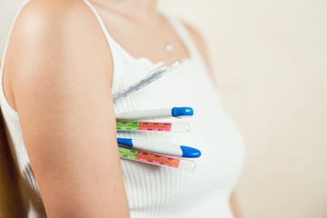 woman holds several thermometers of different types at once