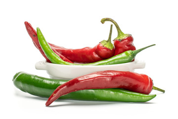 Group of five whole fresh hot pepper in ceramic stewpan isolated on white background
