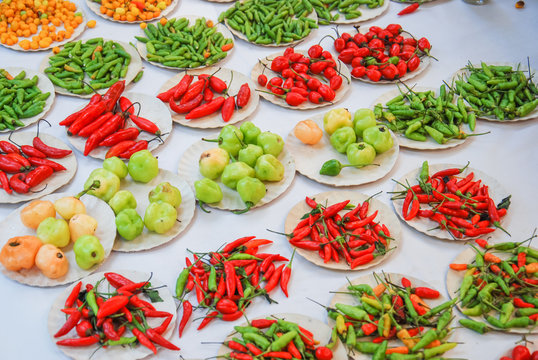Different types of chiles in piles for sale in the agricultural market.