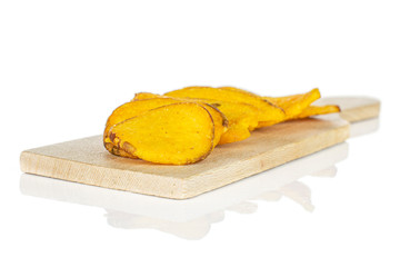 Lot of whole dry vegetable chip of gourd on small wooden cutting board isolated on white background