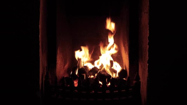 footage of an open fire in a fireplace in an old irish cottage showing yellow flame on black coal