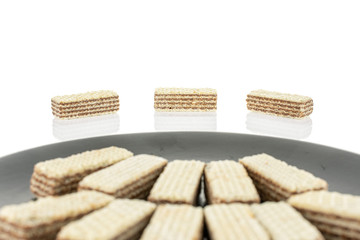 Lot of whole crispy beige hazelnut wafer cookie on gray ceramic plate isolated on white background