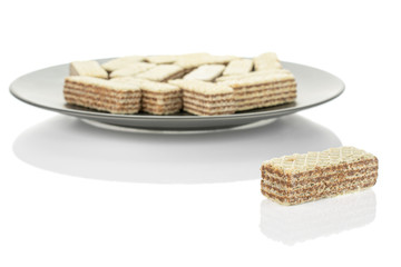 Lot of whole crispy beige hazelnut wafer cookie on gray ceramic plate isolated on white background