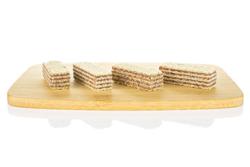 Group of four whole crispy beige hazelnut wafer cookie on bamboo cutting board isolated on white background