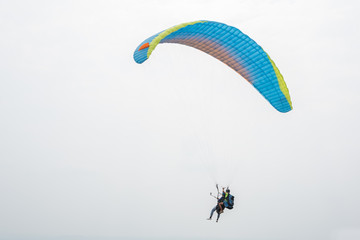 Blue paraglider flying in the sky	