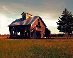 Photo of an old abandoned barn in the country with a dark sky.