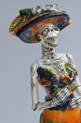 skeleton dressed in typical Mexican costumes celebrating the day of the dead crafts in mud