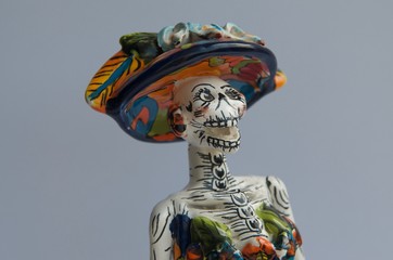skeleton dressed in typical Mexican costumes celebrating the day of the dead crafts in mud