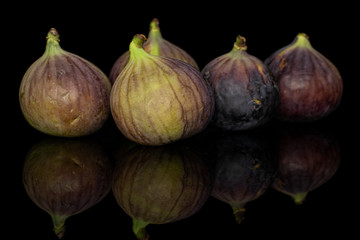 Group of five whole sweet purple fig isolated on black glass