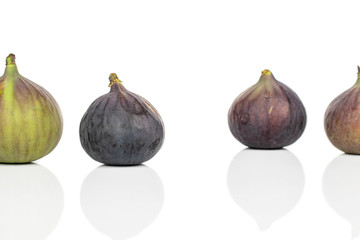 Group of four whole sweet purple fig isolated on white background
