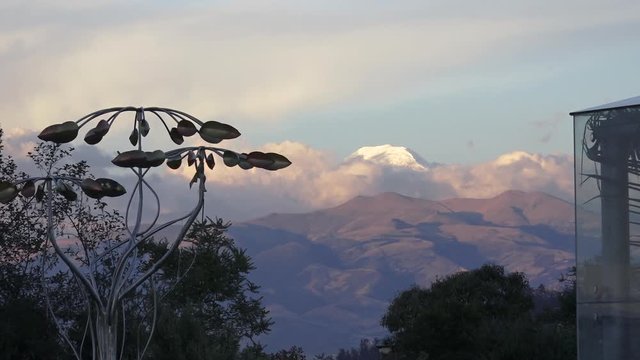 Molino de viento, al fondo el volc&aacute;n Cotopaxi entre nubes