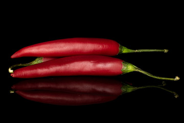 Group of three whole hot red chili cayenne isolated on black glass