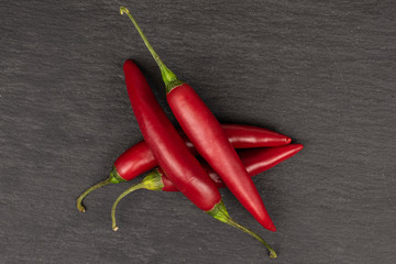 Group of four whole hot red chili cayenne flatlay on grey stone